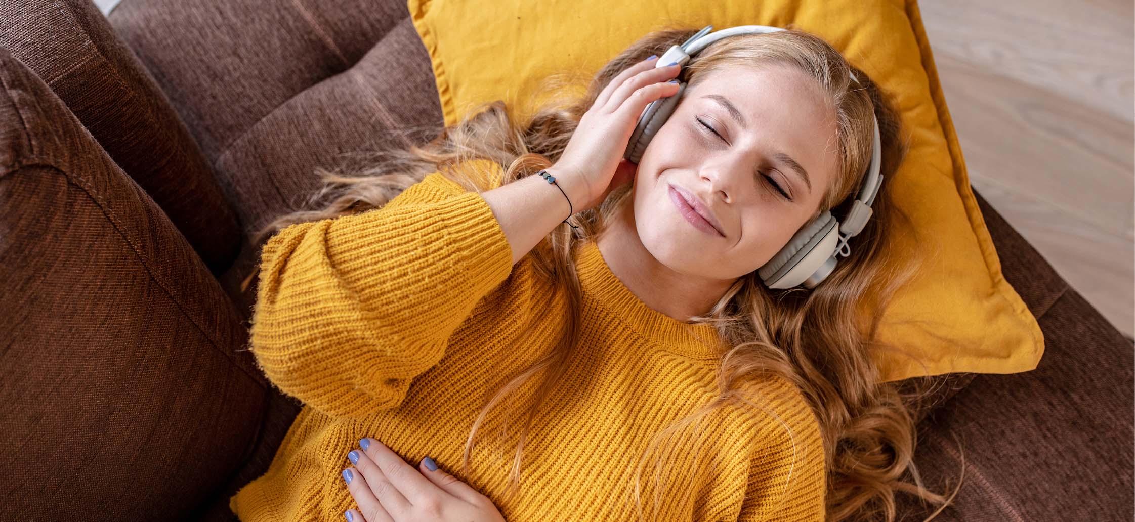 frau-liegt-auf-sofa-hoert-musik